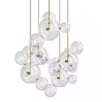 Large Clérachic glass sphere installation with many pendants and clear spheres of mixed sizes, on a white backdrop.