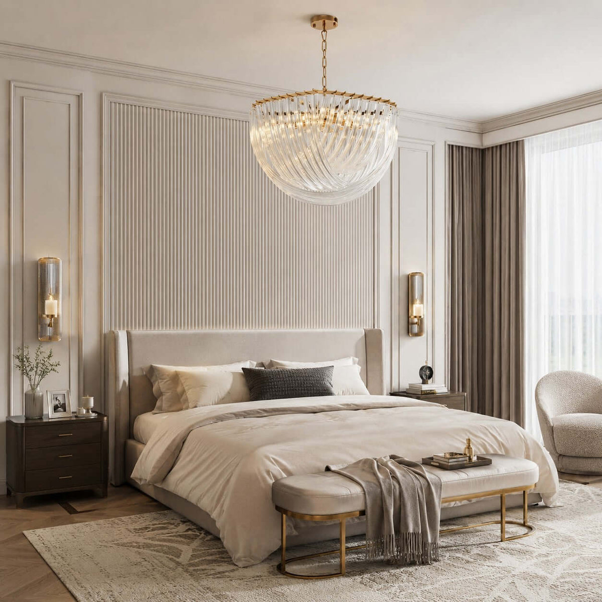 A wide bowl-shaped glass-rod pendant hangs in a calm bedroom with a ribbed headboard wall, a cream bed and a gold-framed bench, from Clérachic.
