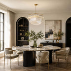 Curved glass rods catch the daylight in this Clérachic pendant, hung over a round marble dining table with cream chairs in an arched, panelled room.