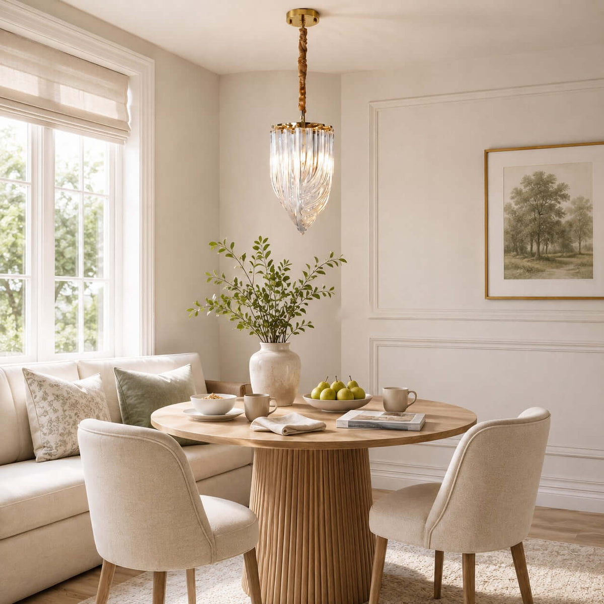 One slender Clérachic pendant with a twisted gold stem and looped glass rods hangs by a window over a round fluted table and a cream banquette.