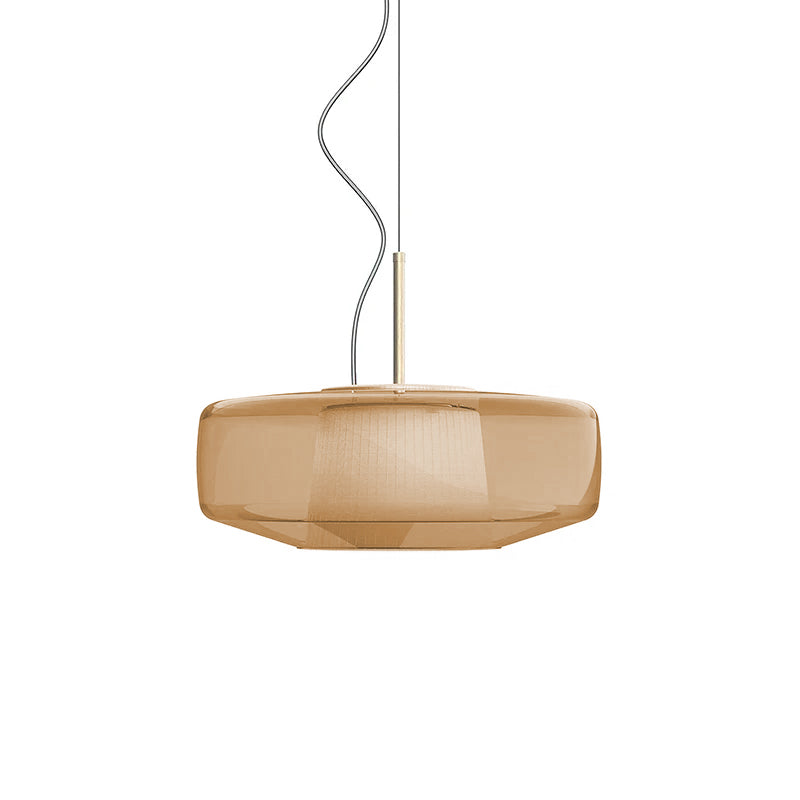 Unlit amber glass Clérachic pendant on a white backdrop, with its faceted shape and the inner shade faintly visible through the glass.