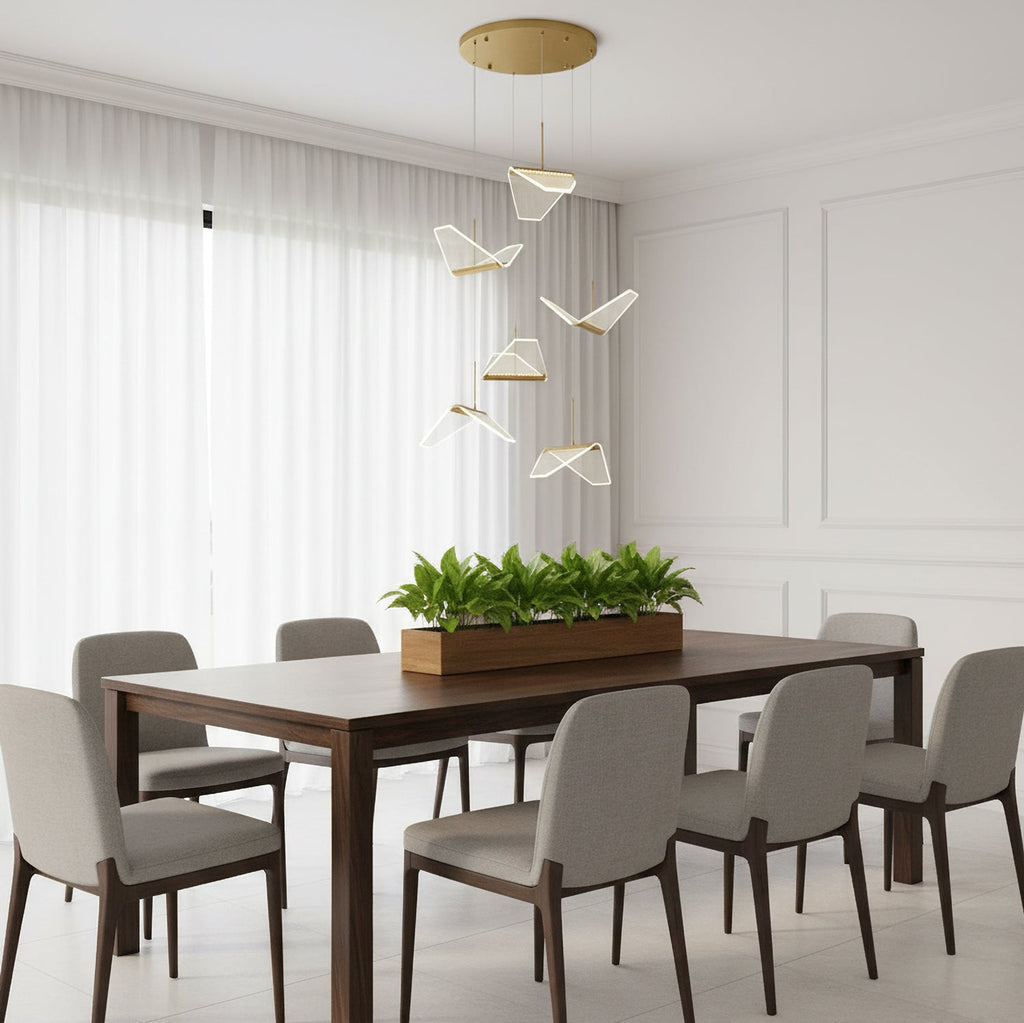 In a bright panelled dining room, this Clérachic pendant light hangs a loose group of folded shades above a long table and a planter.