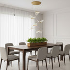 In a bright panelled dining room, this Clérachic pendant light hangs a loose group of folded shades above a long table and a planter.