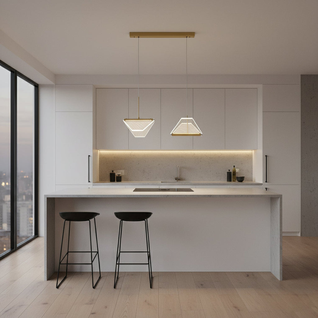 Two folded shades from this Clérachic pendant light hang side by side from a gold bar above a white kitchen island.