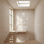 Under a skylight above an open timber staircase, this Clérachic pendant light hangs a few folded shades at different heights.