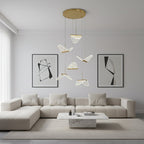Above a cream corner sofa and marble coffee table, this Clérachic pendant light hangs folded shades from a gold plate.
