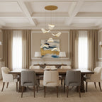 Folded shades from this Clérachic pendant light hang above a long dining table in a coffered-ceiling room with beige curtains.