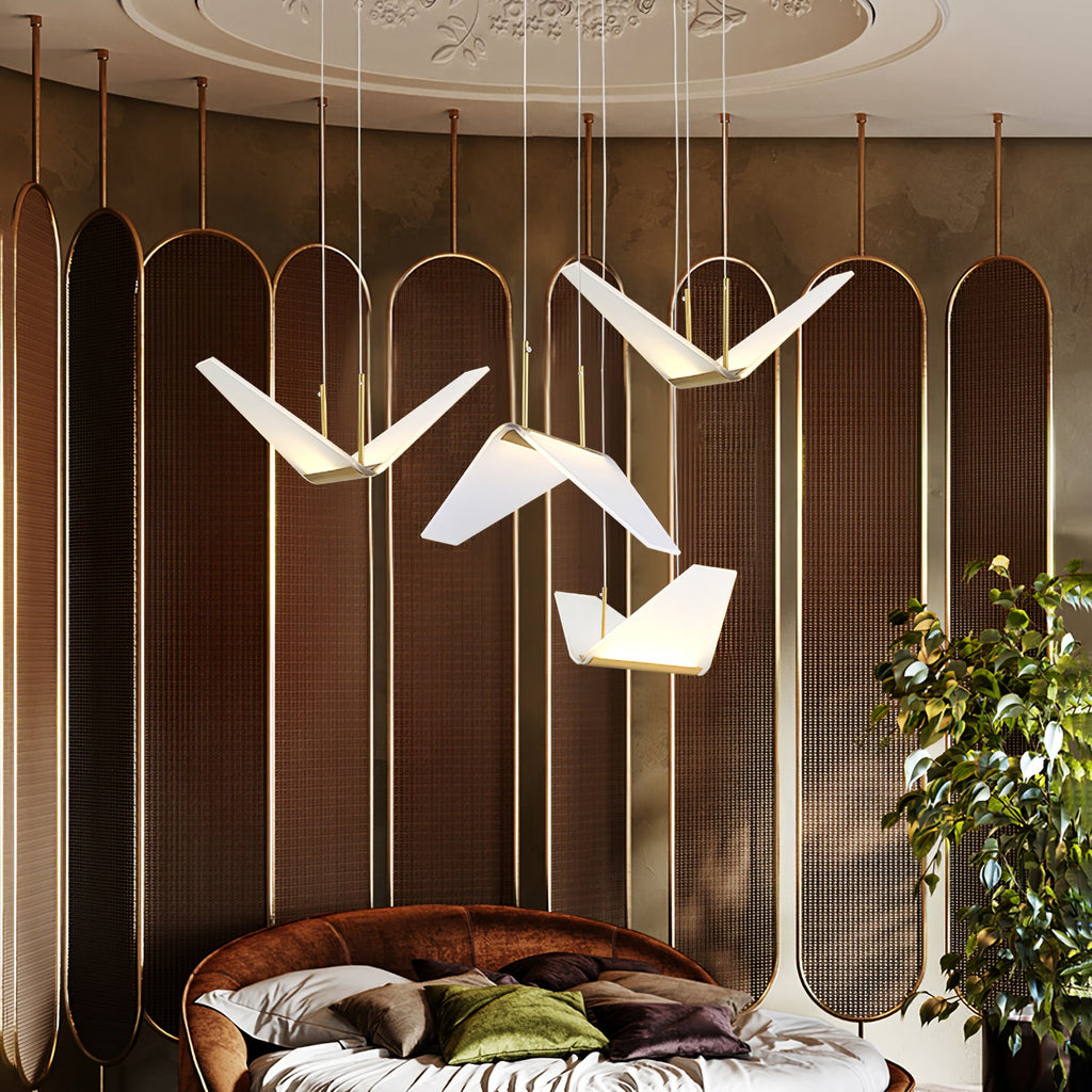 Large folded white shades of this Clérachic pendant light hang before a bronze screen wall above a round bed.