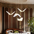 Large folded white shades of this Clérachic pendant light hang before a bronze screen wall above a round bed.
