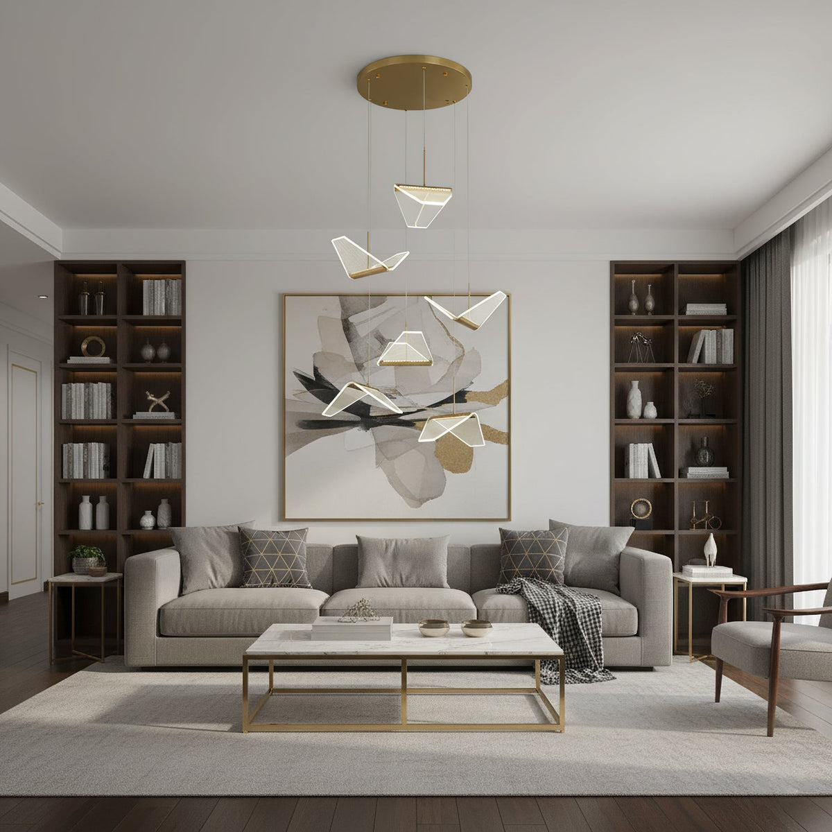A Clérachic pendant light with a few folded shades hangs in a living room with a grey sofa, a brass-framed table and shelving.