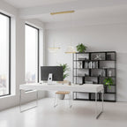 Two small folded shades from this Clérachic pendant light hang from a gold bar over a white desk in a bright, airy office.