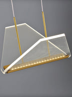 Close view of one folded clear shade of this Clérachic pendant light, with a fine mesh pattern and a row of LEDs along the gold base.