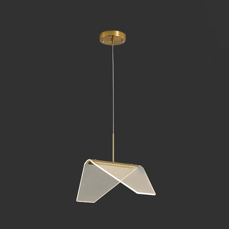 The folded clear shade of this Clérachic pendant light tilted toward the camera on a dark backdrop, with a gold base strip.