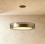 Clérachic's pendant light, its frosted diffuser glowing warm beneath a brushed brass and glass drum.