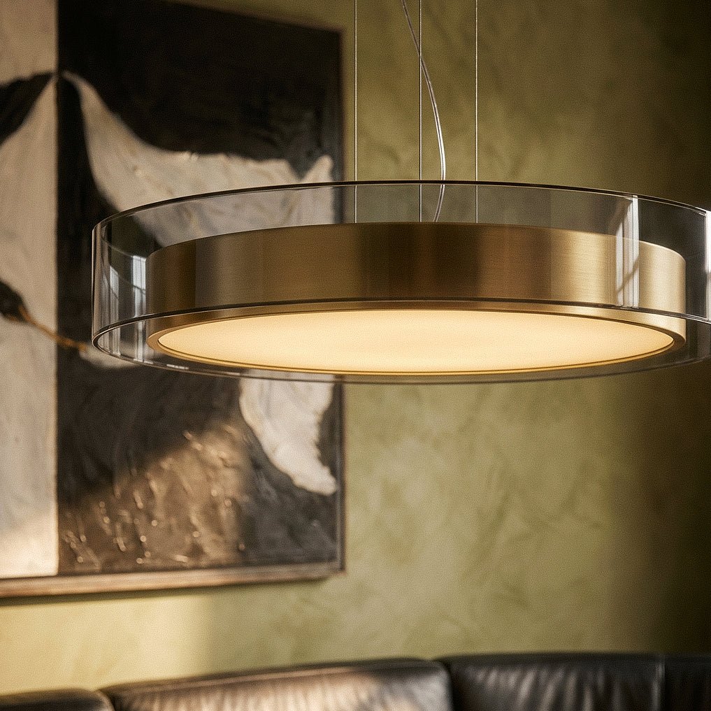 A close detail of the Clérachic pendant light's glass and brass drum against a green painted wall.