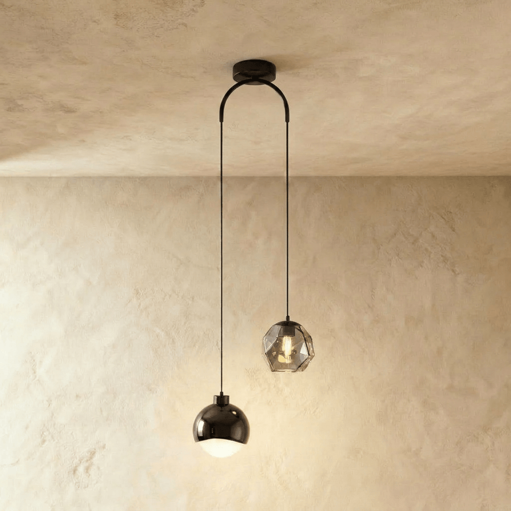 Clérachic pendant light in black, a glossy dome shade and a faceted glass gem hung at staggered heights.