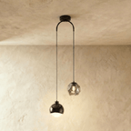 Clérachic pendant light in black, a glossy dome shade and a faceted glass gem hung at staggered heights.