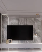 Clérachic pendant light lit warm beside a marble media wall, its dome shade reading pale under cool light.