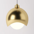 Clérachic pendant light dome shade in gold, its polished curve catching light above the opal diffuser.