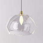 Clérachic pendant light faceted glass shade lit warm, its angled clear panels on a brass cord fitting.