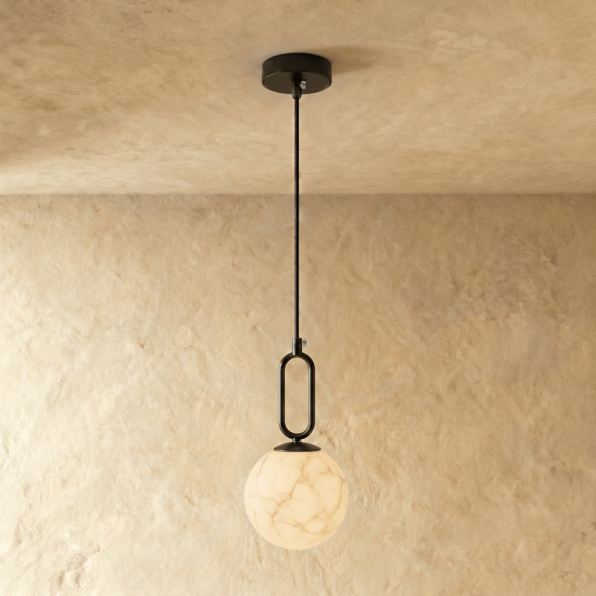Clérachic black-hardware pendant light with a round alabaster globe, hung low on a slim rod from the ceiling.