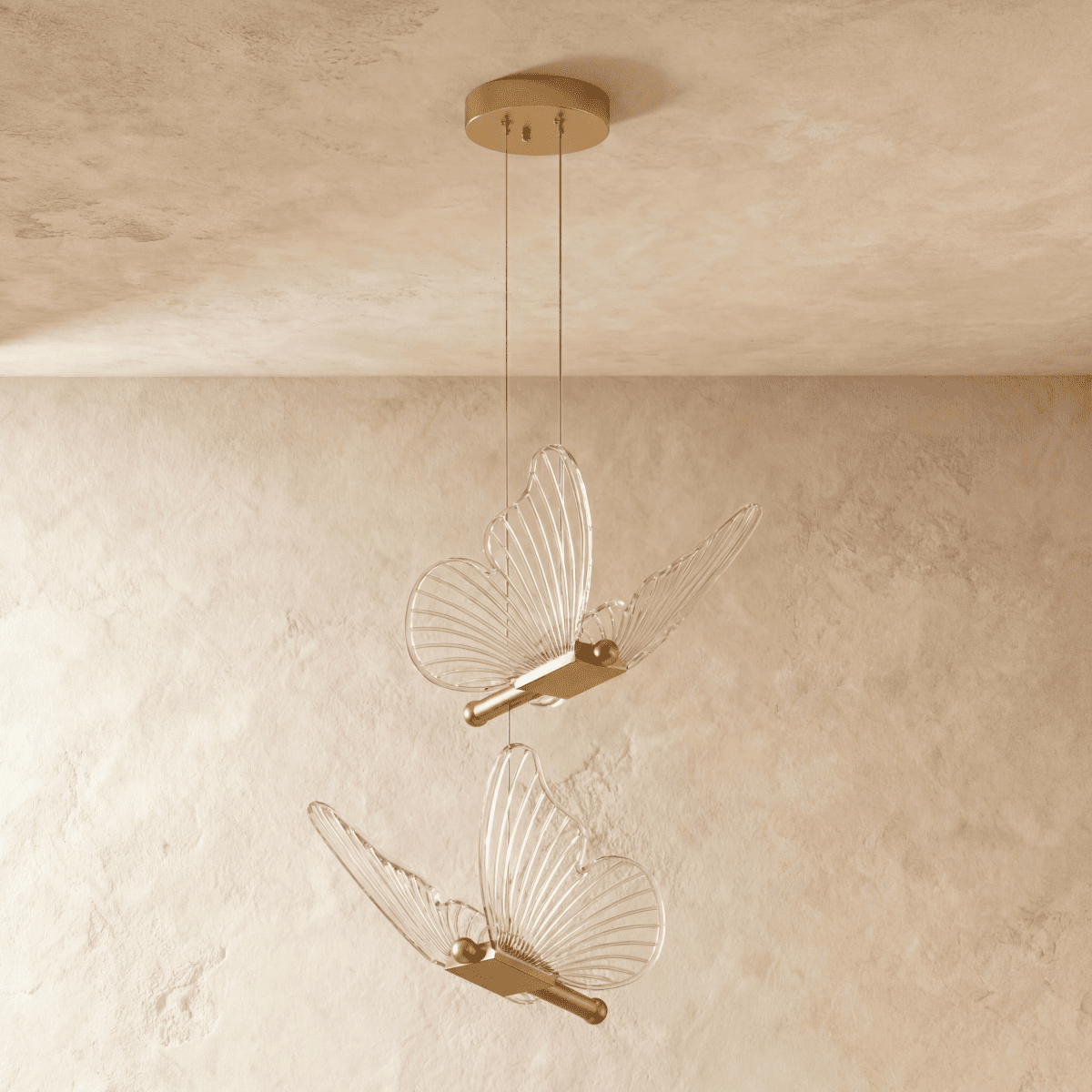 Clérachic brass double-head butterfly pendant light, two clear wing fixtures suspended at different heights.