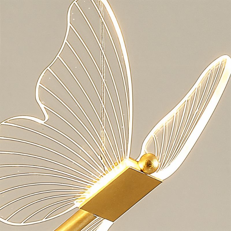 Clérachic brass butterfly pendant light in close detail, showing the glowing ribbed wing edges and brass body.