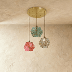 Clérachic round-canopy trio of glass petal pendants in blue-green, coral pink and clear, hung at different heights.