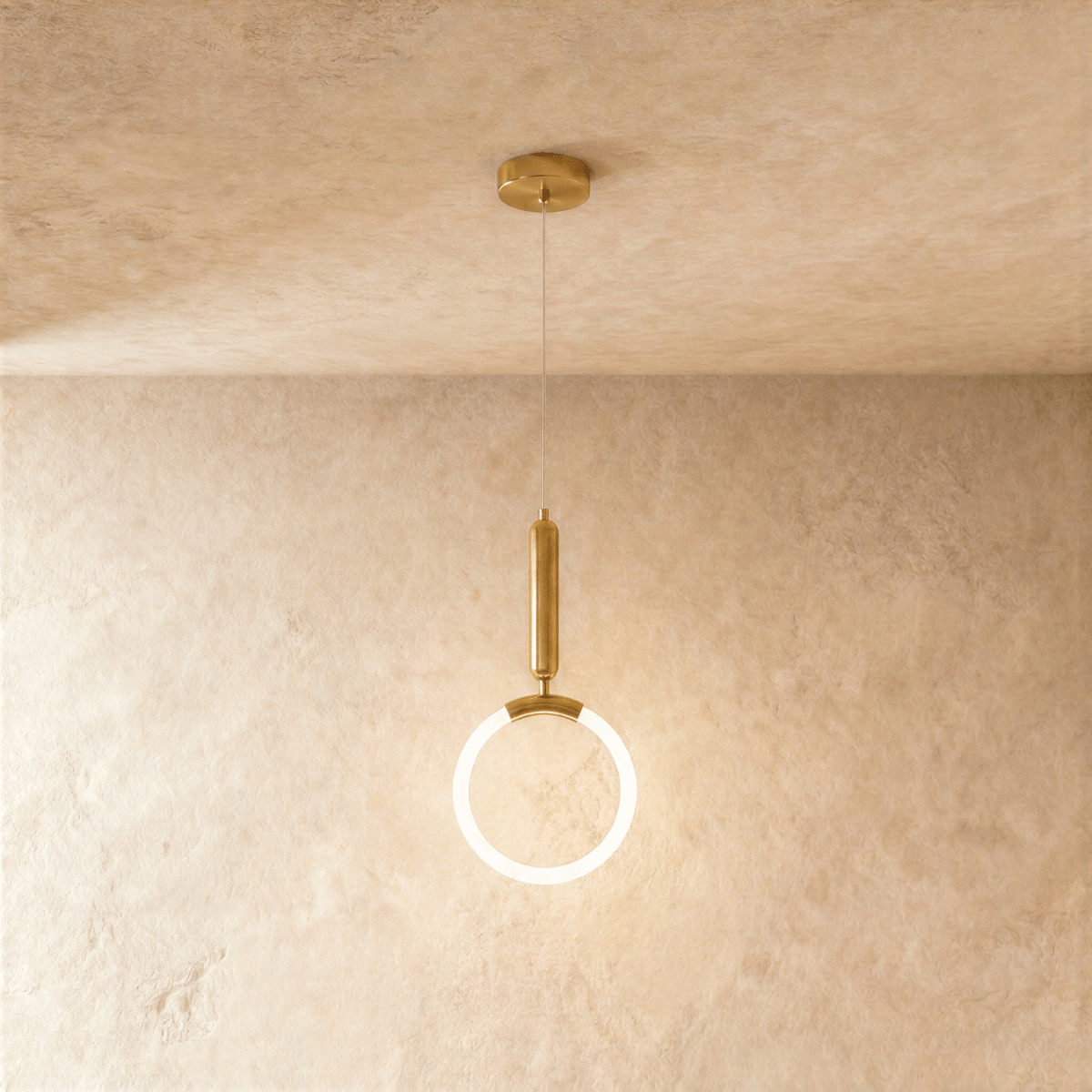 Clérachic gold pendant with a glowing opal ring and a rounded brass handle above, hanging from a ceiling plate on wire.