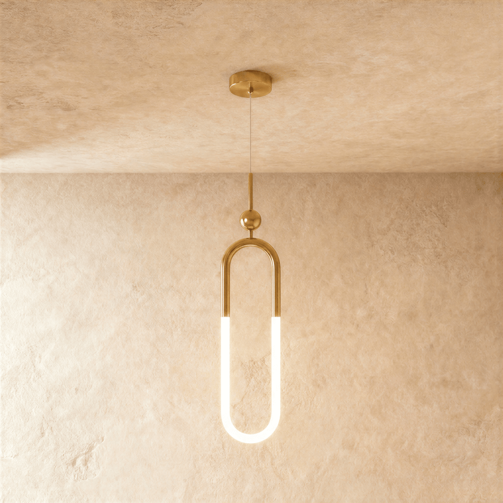 Clérachic gold pendant with a tall U-shaped brass frame, a glowing opal lower tube and a small ball above, hung on wire.