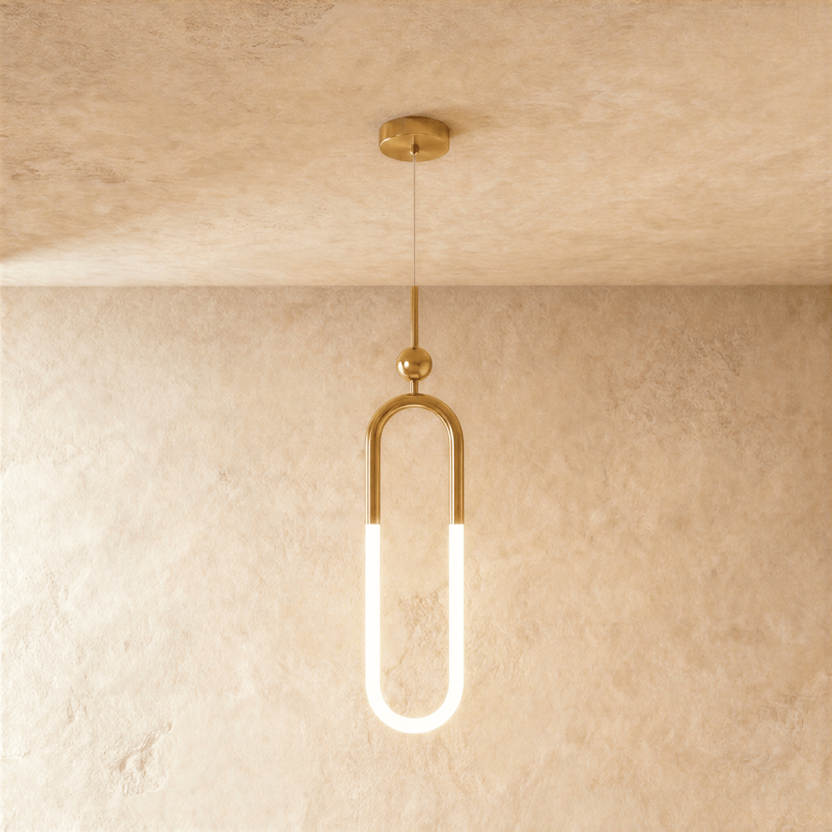 Clérachic gold pendant with a tall U-shaped brass frame, a glowing opal lower tube and a small ball above, hung on wire.