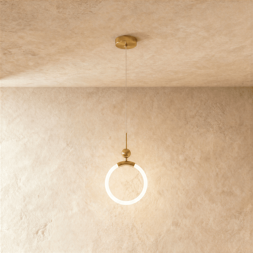 Clérachic gold pendant with a glowing opal ring, small brass ball and thin rod, hung from a round canopy on fine wire.