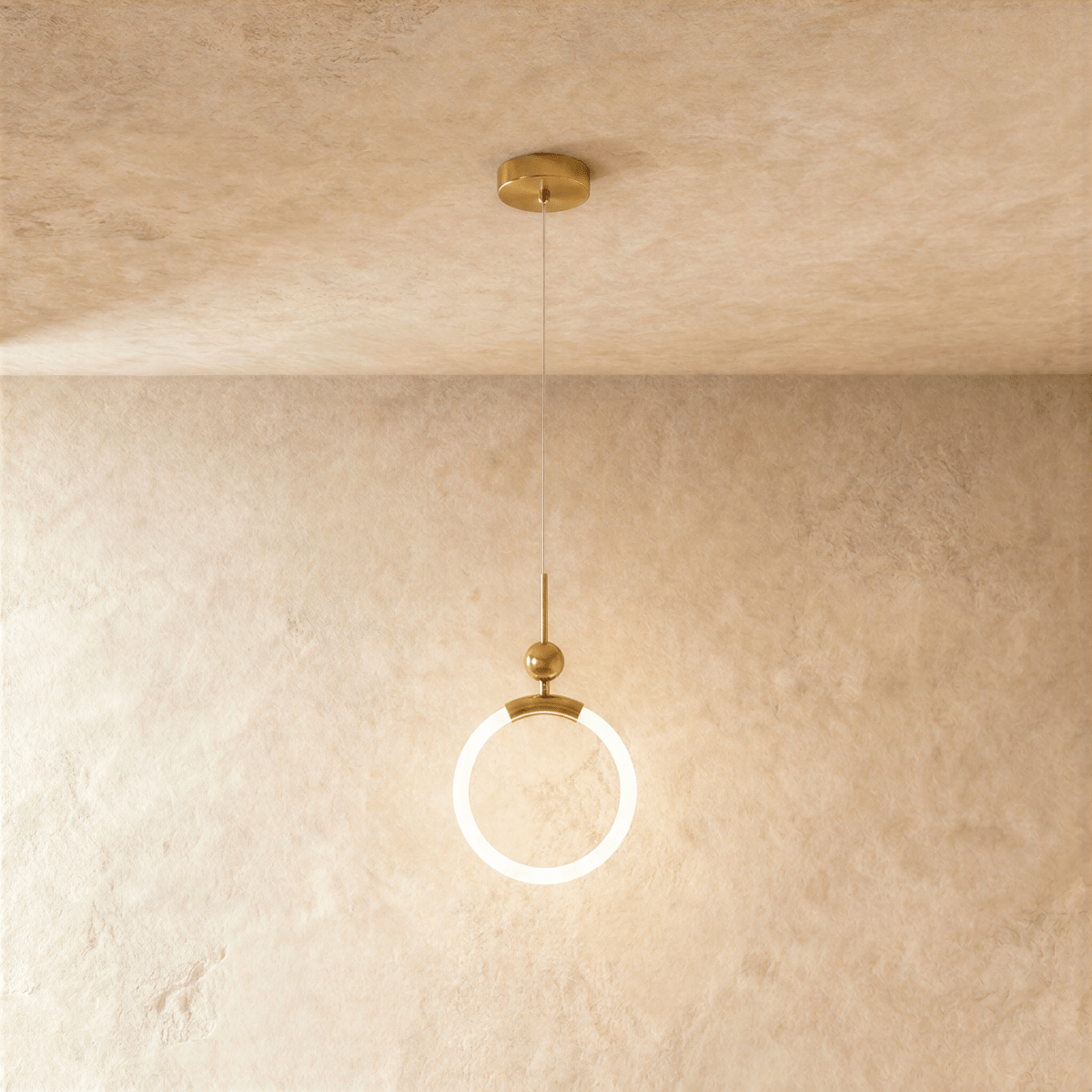 Clérachic gold pendant with a glowing opal ring, small brass ball and thin rod, hung from a round canopy on fine wire.