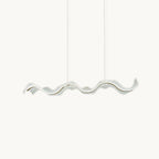 Long wavy acrylic shade with a thin gold line, hung on two fine wires, this Clérachic pendant on a plain white backdrop.