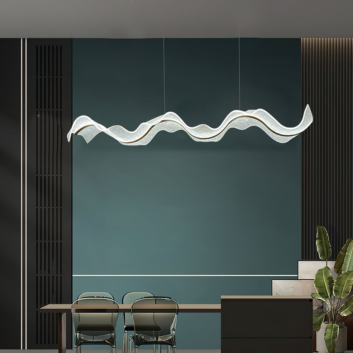 Wavy linear pendant from Clérachic glowing in front of a deep teal wall, with a dining table and glass chairs in the lower corner.