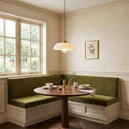A Clérachic ribbed pendant hangs above a round wooden table and a green velvet banquette, beside a framed botanical print.