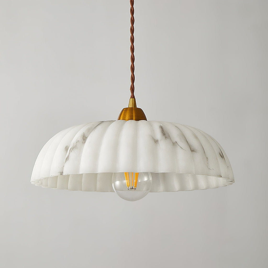 A Clérachic pendant with a shallow ribbed white shade, a gold cap and a visible filament bulb, on a light grey backdrop.