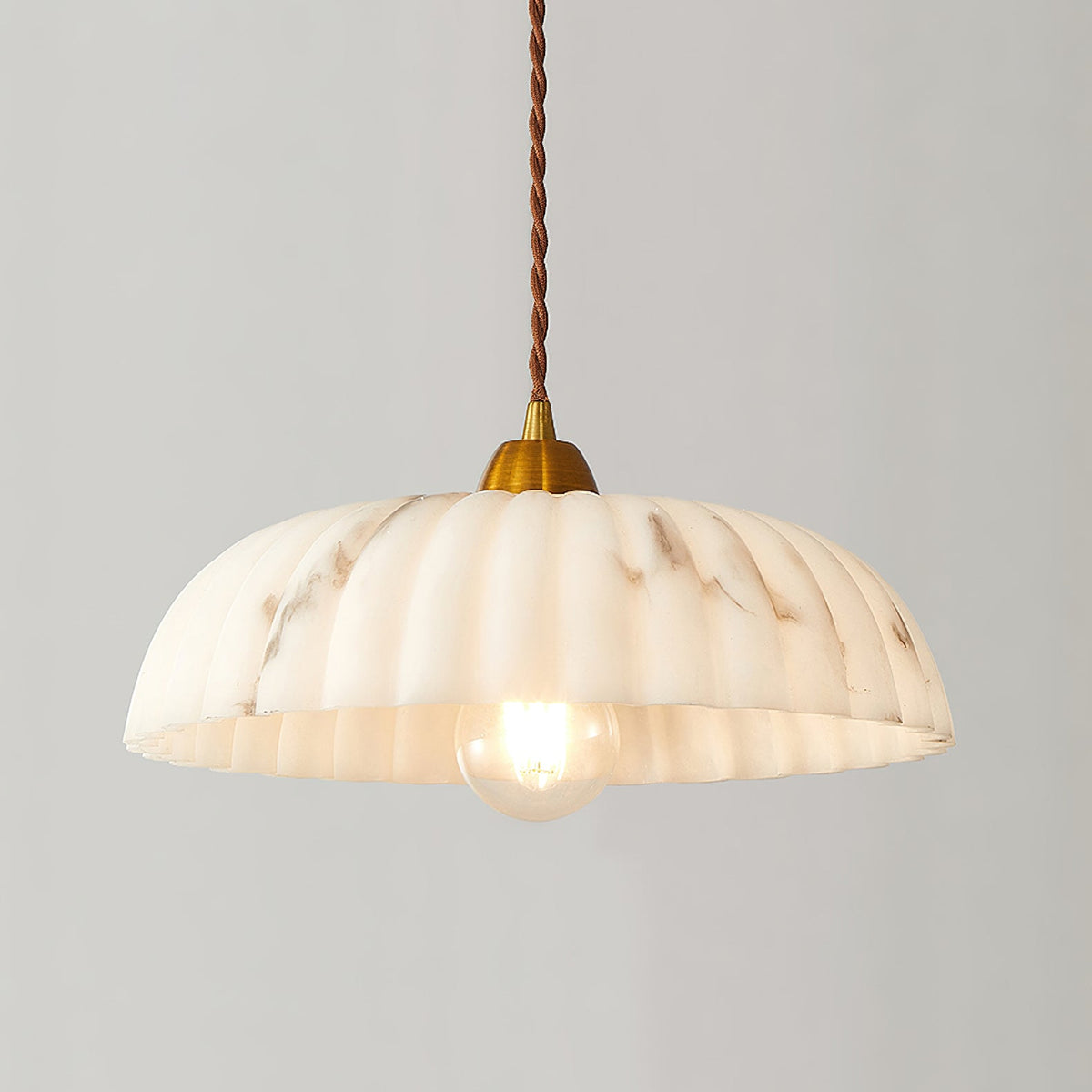 Ribbed white shade with fine brown veining on this Clérachic pendant, lit warm on a light grey backdrop.