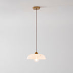 Full drop of a Clérachic pendant from a gold ceiling plate on a twisted brown cord to a small ribbed white shade.