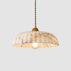Ribbed shade with warm brown and cream veining on this Clérachic pendant, lit with a filament bulb on a light grey backdrop.