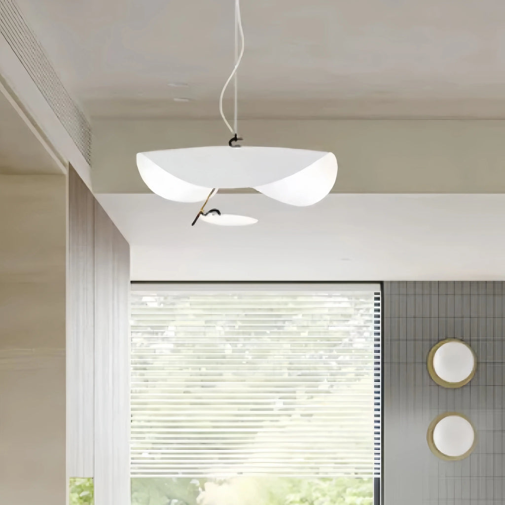The white-and-gold Clérachic pendant light glowing above a light wood console near an open bedroom doorway.