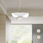 The white-and-gold Clérachic pendant light glowing above a light wood console near an open bedroom doorway.