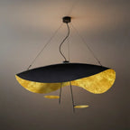 Studio shot of the Clérachic pendant light in black and gold, a single round accent disc centred on its drop stem.