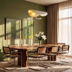 Clérachic white pendant with gold-leaf interior above a walnut dining table with cane chairs, in a green room with sheer curtains