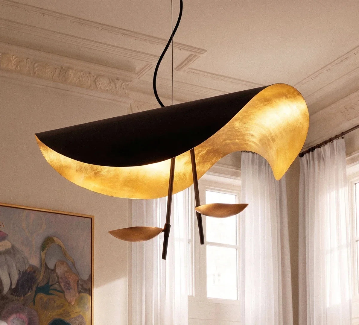 Close view of the Clérachic black pendant: curled shade with glowing gold-leaf lining and two bronze-toned discs on dark slim arms