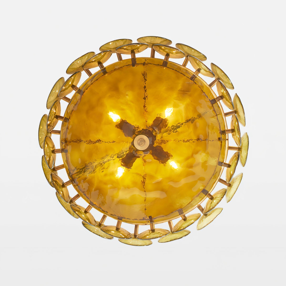 Looking up at the underside of this Clérachic chandelier, a glowing amber bowl ringed by overlapping gold-green glass discs.