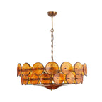 Amber disc chandelier from Clérachic with a smaller spread, hanging by a brass chain against plain white.
