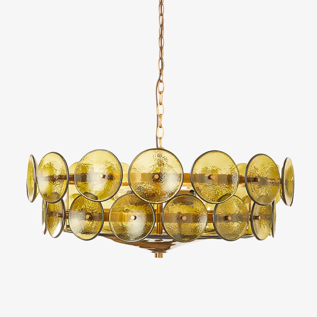 Close crop of the green-gold glass discs and the gold chain on a Clérachic chandelier, in front of a pale grey backdrop.