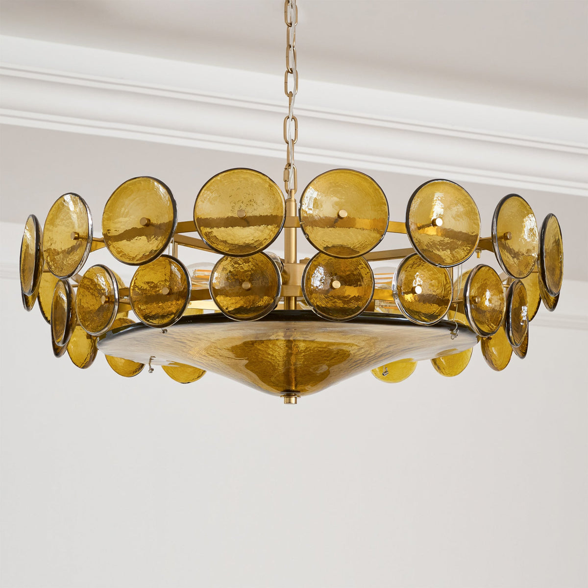 Green-gold glass disc chandelier from Clérachic seen from below, with a wide hammered glass bowl hanging under two rings of discs.