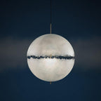Frosted sphere with a dark jagged band around the middle, this Clérachic pendant against a deep navy backdrop.